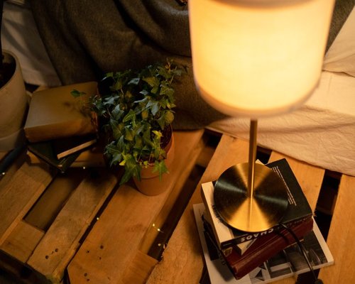 A cozy indoor room with warm lamplight illuminating an open reading book